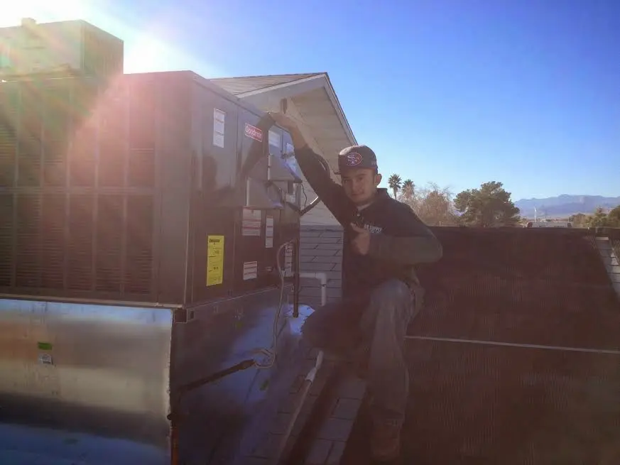 HVAC technician performing Heat Pump Repair on a rooftop unit in Elkhart